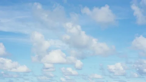 Light fluffy clouds fly quickly across the summer blue sky. Stock Footage 144571354