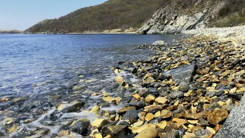 Light foamy wave breaks on the pebble shore. High quality 4k footage Stock Footage 309734620