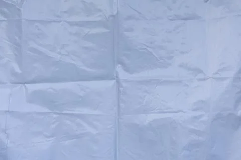 Light folded plastic sheet surface with creased geometric texture pattern Stock Photos