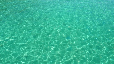 Light forms multiple patterns across the turquoise waters of a tropical Stock Footage 105384225