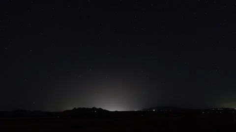 Light glow from a small town with time lapse of stars overhead Stock Footage 304906582