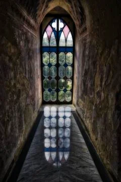 Light from a gothic glass window is reflecting on the lucid floor Stock Photos