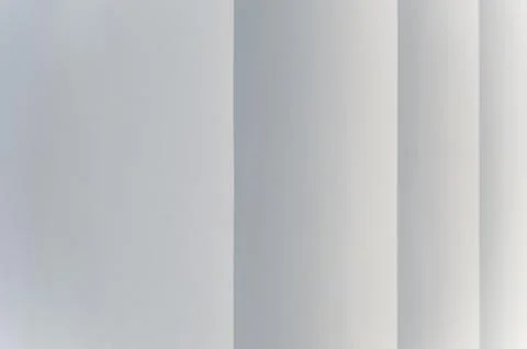 Light gray abstract background with vertical stripes that taper. Stock Photos