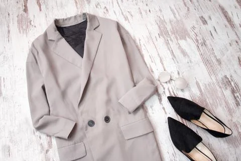 Light gray coat and black shoes on a wooden background. Fashion concept. top  스톡 사진