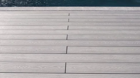 Light gray composite deck boards with wood texture by the pool edge. Modern surf Stock Footage 312019070