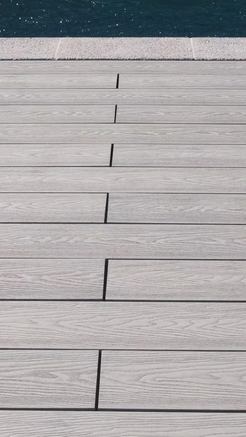 Light gray composite deck boards with wood texture by the pool edge. Modern surf Stock Footage 312019083