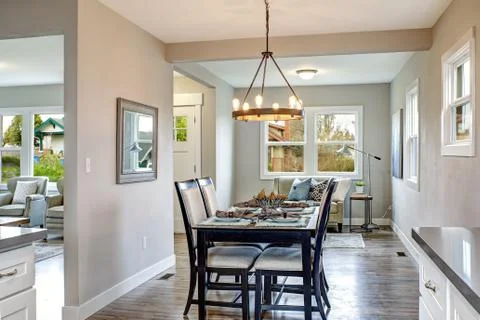 Light gray interior of transitional dining room in a freshly remodeled house. Stock Photos