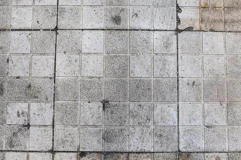 Light gray tiled pavement with subtle grime and weathering, showing slight varia Stock Photos