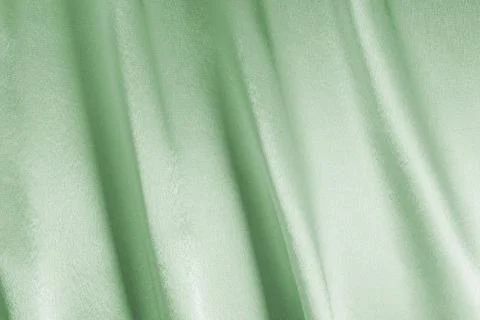 Light green background or pattern of fabric with folds or waves, close-up Foto stock