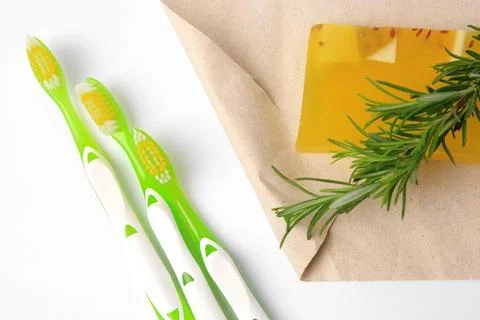 Light green toothbrushes, solid soap and rosemary on white background, top vi Foto stock