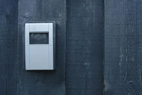 A light grey key safe wall safe with combination lock is attached to a dark.. Stock Photos