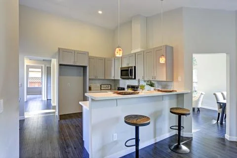 Light grey kitchen room interior with bar style kitchen island and round stoo Foto stock