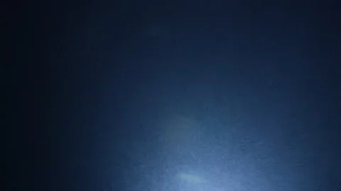 The light of a headlamp illuminates the snow that falls in the night Stock Footage 229682836