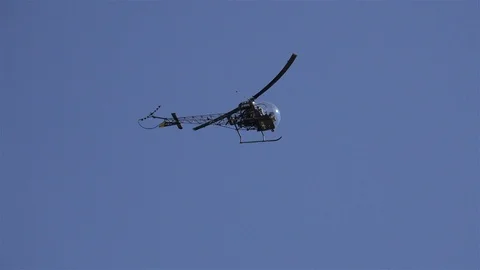Light helicopter Bell 47 flying close up in blue sky Stock Footage 114004876
