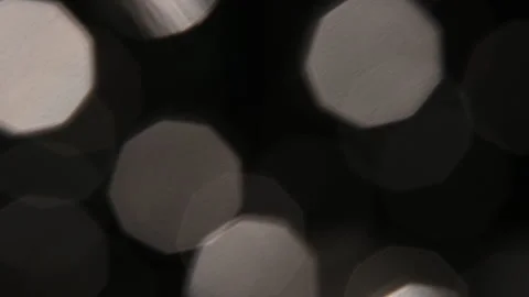 The light hits the lens and creates beautiful highlights and bokeh on a dark Vídeo Stock 303641696