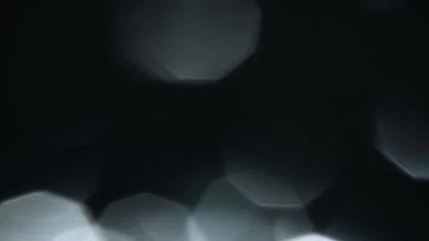 The light hits the lens and creates beautiful highlights and bokeh on a dark 動画素材 303642264