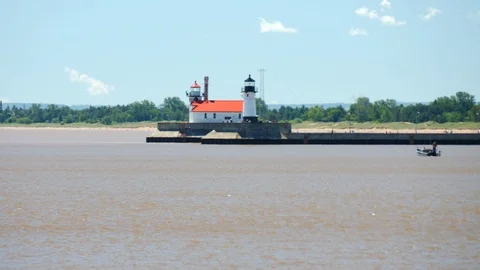 Light House in distance across Lake Superior two light houses boats zoom Lake Stock Footage