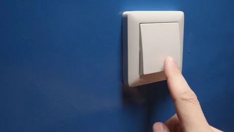 Light is Off - Human hand switch off a button on a blue wall - side view Stock Footage 75564762