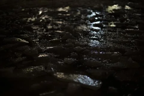 Light on ice in dark. Reflection of artificial light on frozen water. Stock Photos