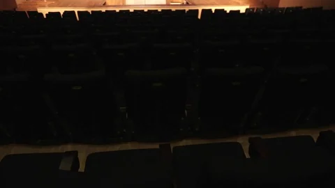 Light illuminating chairs in a  Auditorium Stock Footage 73318348
