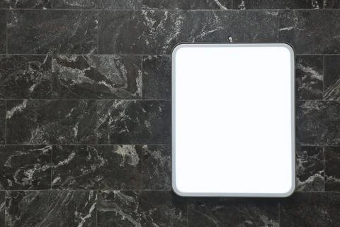 Light information panel on the wall of dark marble tiles Stock Photos