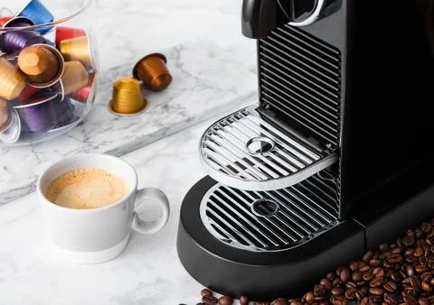 Light kitchen with coffee machine and cup of aroma coffee with capsules pods Stock Photos