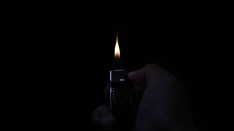 Light a lighter with a lighter in the dark until you can't see anything. Take Stock-Footage 168519134
