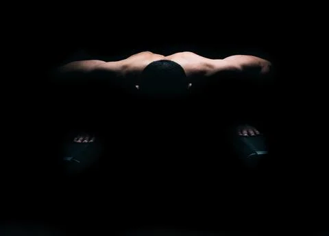 The light lighting the back of a man that is doing push-ups Stock Photos