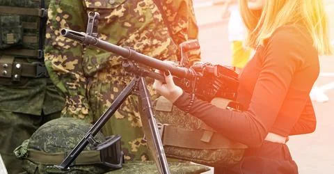Light machine gun in young hands with black manicure. Stock Photos