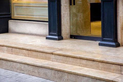 Light marble threshold with steps at the entrance to the glass door. Stock Photos