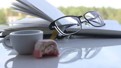 Light notepad, glasses with black edging, candy, cup of white coffee, Morning Stock Footage 92205974