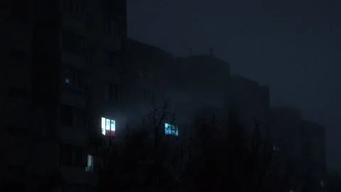 Light in one window in apartment multistorey building in fog during blackout Stock Footage 223216348