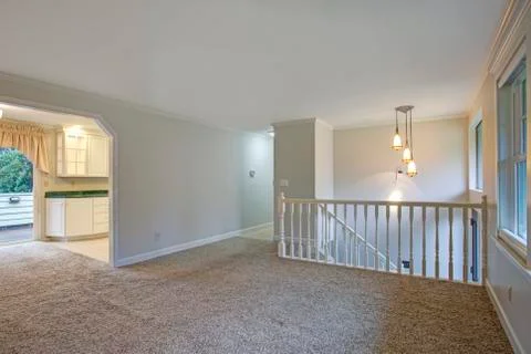 Light open second floor landing with carpet floor and white railings. Stock Photos