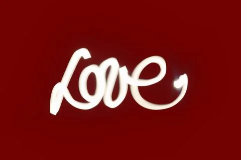 Light Painted Love. White cursive love light painting on a deep red background. Stock Photos