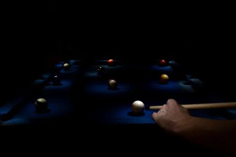 A light painted portrait of a billiard table with lit billiard balls and a pe Stock Photos
