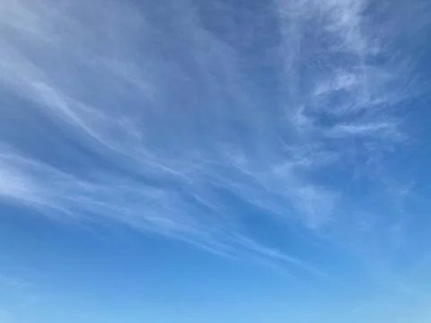 Light pale white clouds on the blue sky in natural daylight Stock Photos