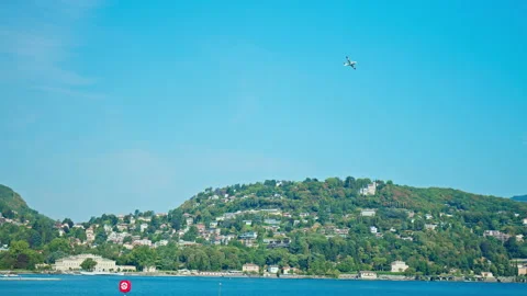 Light Passenger Jet flying above Lake Como in Italy on a sunny summer day. Stock Footage 237140400