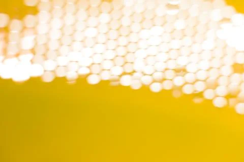 The light passes through the mesh structure, forming blurred hexagonal spots Stock Photos