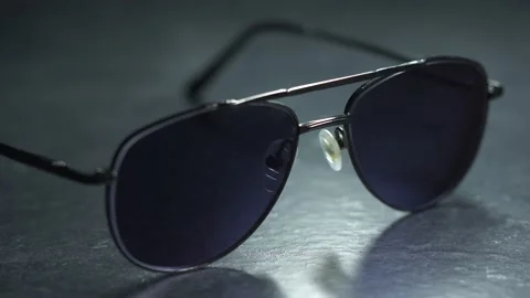 Light Passing Over Aviator Style Sunglasses Dramatic Closeup Stock Footage 131105101