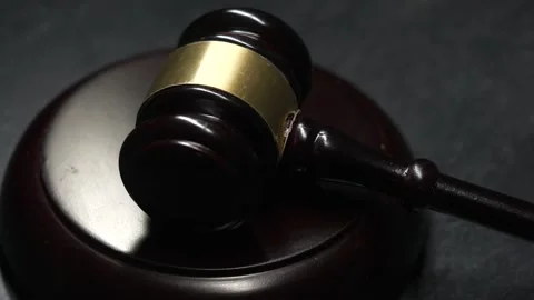 Light Passing Over a Judge Hammer and Gavel Dramatic Closeup Stock Footage 131104698