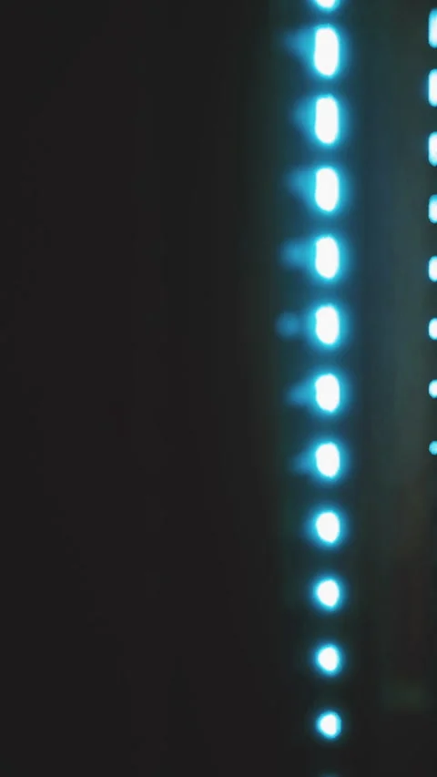 Light patterns create a mesmerizing visual dance in a dark space Video stock 334212492
