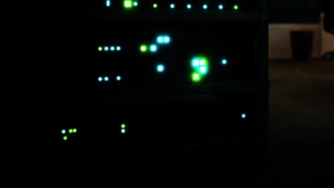 Light patterns from electronic equipment in a dark room in an office setting Stock Footage 345006034