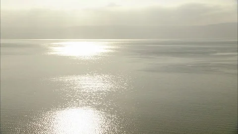 Light patterns on Sea of Galilee with plants and trees in silhouette Stock Footage 95600685