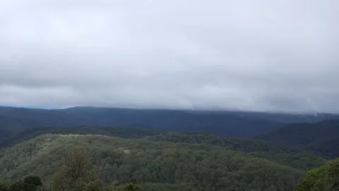 Light Peaks Through Low Cloud Coverage Moving Slowly Over The Mountains Stock Footage 136990944