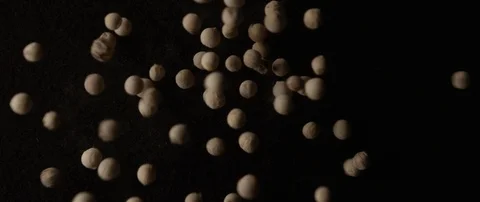 Light pepper peas falls out of focus on a dark surface Stock Footage 106008746