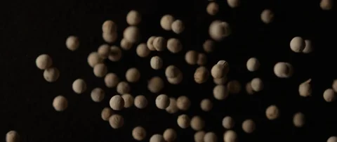 Light pepper peas falls out of focus on a dark surface from behind the camera Stock Footage 106008765