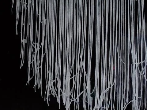Light performance: countless white stripes hanging in the air, abstract scene. Stock Photos