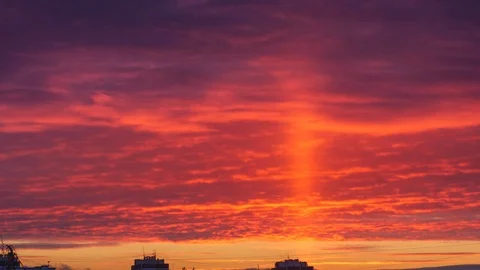 Light pillar atmospheric effect from sunset sun over epic red clouds. Zoom in 4K Stock Footage 100885248