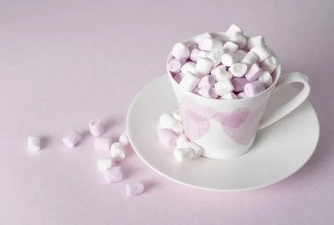Light pink and white marshmallows in a beautiful ceramic cups with pink hearts Stock Photos