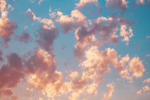 Light pink clouds on blue sky. Romantic sunset of day. Nature Stock Photos